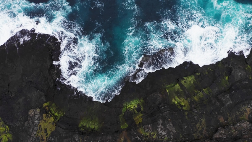 Aerial view of waves break on rocks of Faroe islands cliffs in a blue ocean.Drone Aerial Footage of green nature and the ocean. Royalty-Free Stock Footage #1083845959