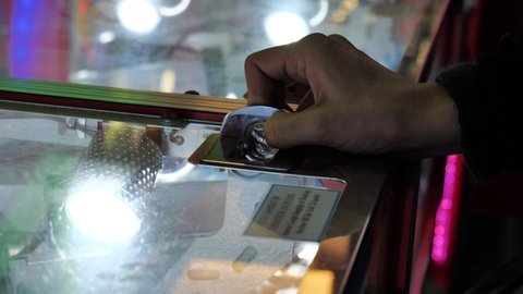 SWANAGE, UK - NOVEMBER 5, 2021: Inserting coins into an arcade gaming in Swanage, Dorset, UK.