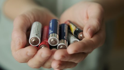 Hands holding alkaline batteries heap. Concept of Recycling, energy, power, environment and ecology. Close up