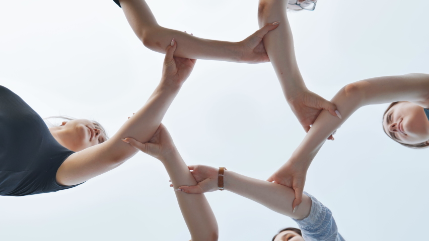 Friends join their wrists and make a circle. Strong friendship concept.