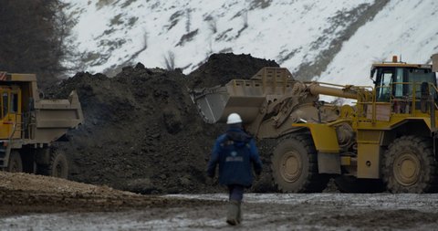Yakutsk, Russia - December, 2020: excavator loads rocks into a bulldozer