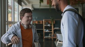 Young man with Down syndrome and his tutor greeting and looking at camera indoors at school. - Powered by Shutterstock - Get 15% off with code: PIKWIZARD15