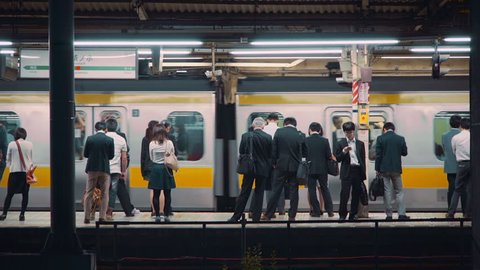 TOKYO - JUNE 1 2015: People wait  to board trains at the subway station in Ochanomizu, Tokyo, Japan.