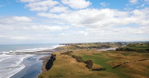 Aerial above coastal cliffs, to Patea River mouth, and groynes -New Zealand