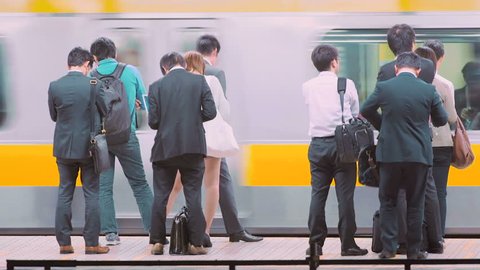 TOKYO - JUNE 1 2015: People waiting to board a train at the  Ochanomizu subway station in Tokyo, Japan.