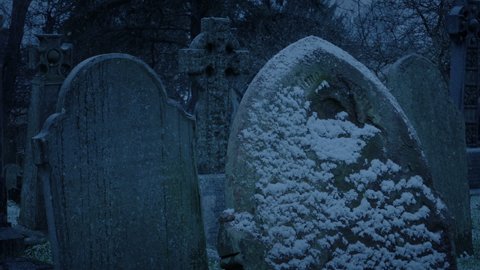 Snow Falls On Gravestones In The Dark