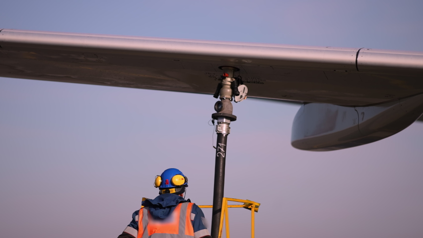 Airport airplane crew refueling aircraft on airline by technical staff maintenance ground. Preparing airplane for departure. repair of aircraft service worker use fuel hose on aircraft wing, on stairs Royalty-Free Stock Footage #1083871447