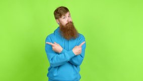 Redhead man with long beard pointing to the laterals having doubts over isolated background