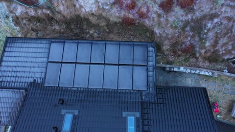 Frozen solar panels with zero electricity production during dark winter season - Upward moving top-down aerial of private home in Norway