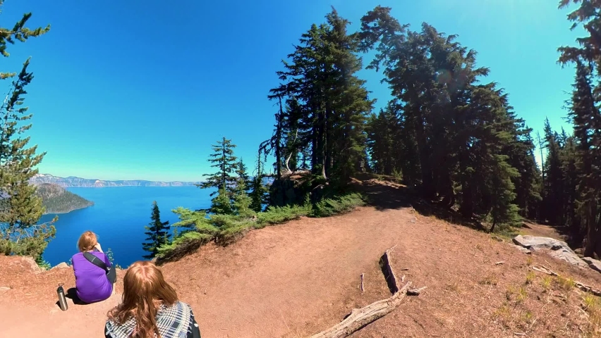 To hikers take a break next the edge of Crater Lake National Park.