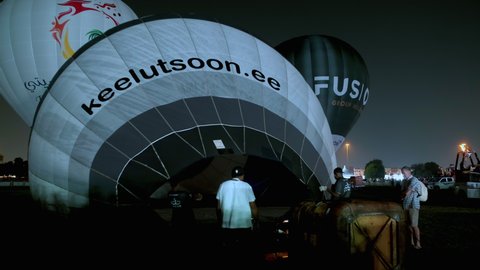 Doha, Qatar- December 9 2021: Qatar Hot Air Balloon festival in Aspire park night shot showing Participants heat the air to inflate the hot-air balloons