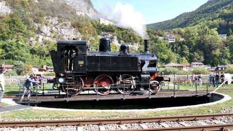 Primolano Vicenza Italy OCTOBER, 10, 2021 Black locomotive steam train drive-off wheelbase turntable on old railway technology display show in Italy while tourist watching