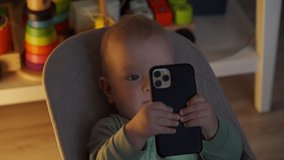 Baby boy playing with mobile phone at home, father takes the smartphone away from kid, the child starts crying. High quality 4k footage