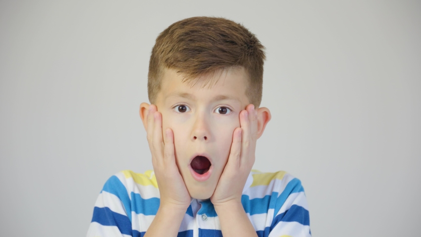 Sincere amazement. Cute boy with wide opened eyes shocked and mouth open. studio footage 4K | Shutterstock HD Video #1083886684