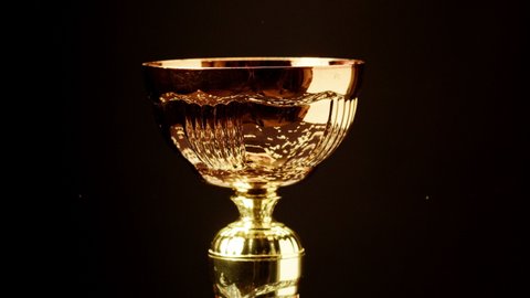 Golden cup on black background close-up. Having first place. Award and victory, winning the championship, success. 