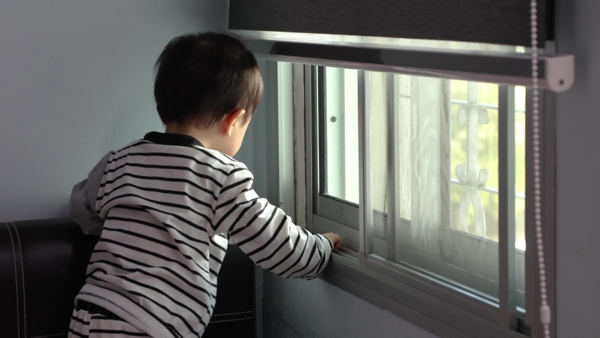 cute Asian Chinese 1 years old Asian Chinese baby boy playing around windows.