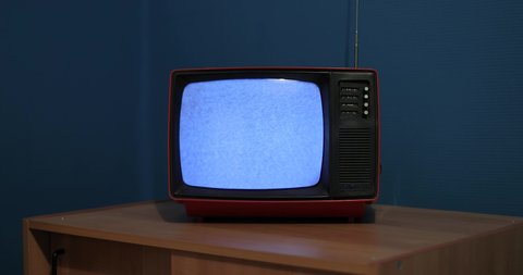 Old TV set with no reception noise in a dim room glow of the screen. Black and white television, dim bedroom
