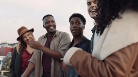Multi-ethnic group of adult friends cheerfully socializing on a rooftop balcony in the city. - Powered by Shutterstock - Get 15% off with code: PIKWIZARD15