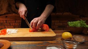 Cutting red tomatoes with a knife. 