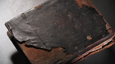 Rotation of an old thick church book with a wooden damaged, badly worn binding. 4K