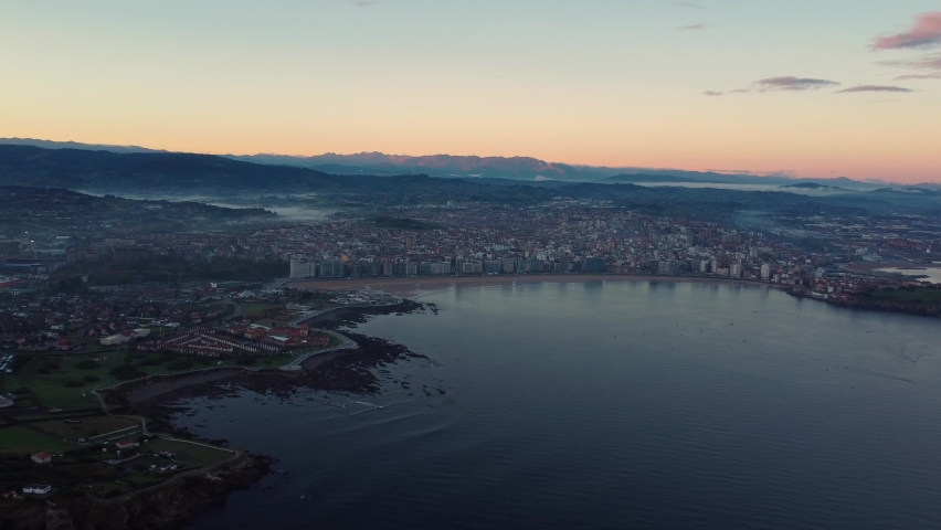 Gijon drone fly above the city in north of Spain, sunset aerial view of sand beach tourist holiday destination