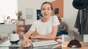 Split screen shot of female student sitting at desk in her dorm room and listening to teacher on video call