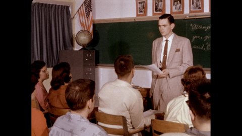 1950s: Slate. Sentence without punctuation written on a chalkboard. Slate. Story "The Last Viking". Slate. Teacher talks in front a classroom of students.