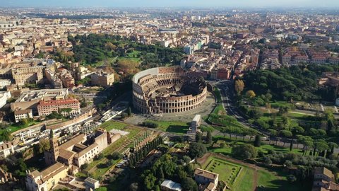 Aerial drone video of iconic and beautiful ancient Arena of Colosseum, also known as the Flavian amphitheatre in the heart of Rome, Italy