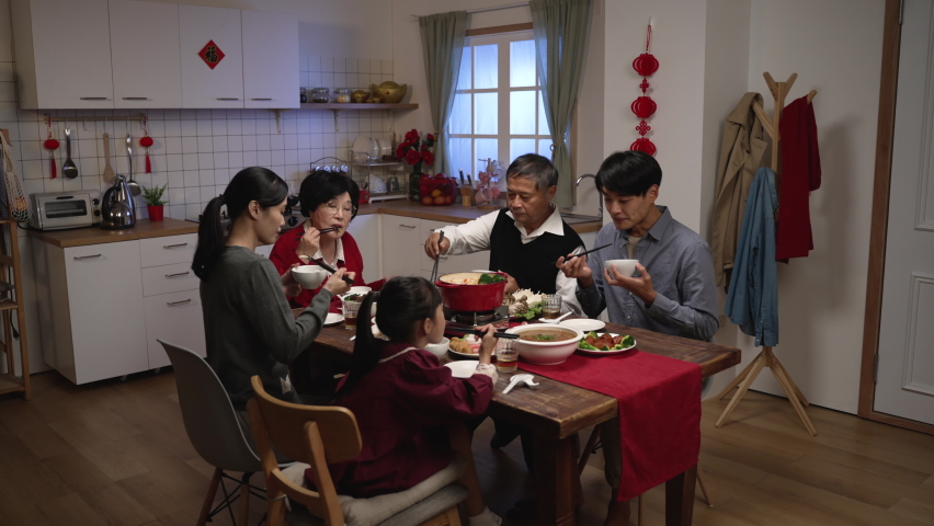 happy asian extended family laughing at the man