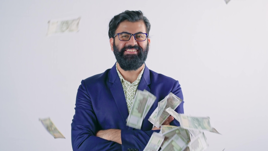 young Indian Asian attractive bearded male standing with smiling face folded arms under raining notes or cash or money over him. The success, lottery, jackpot, prizes, a wealth of a business concept. Royalty-Free Stock Footage #1083918616