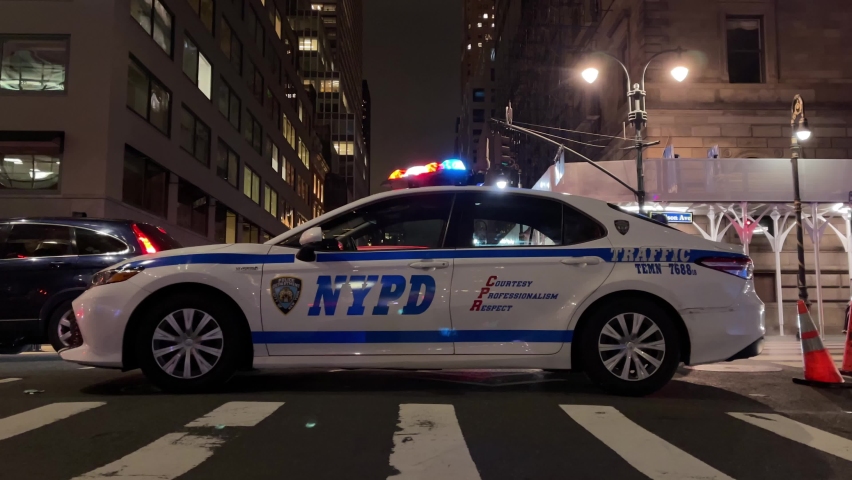 NYC, USA - DEC 8, 2021: police NYPD cop car flashing turret lights and cones night New York City.