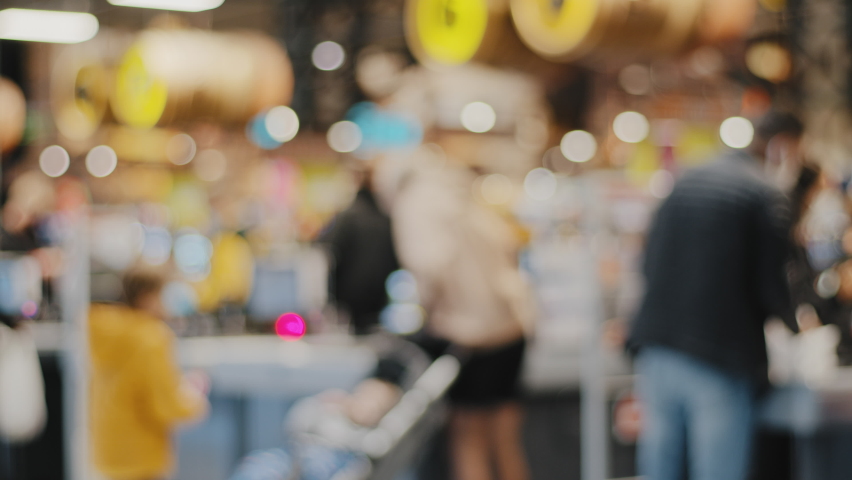 Blurred view unfocused unrecognizable people in store man and woman shoppers consumers customers at checkout in supermarket shopping mall buying groceries food standing at queue paying money Royalty-Free Stock Footage #1083919123