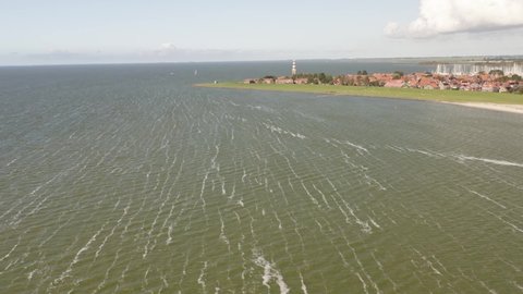 Aerial shot approaching the scenic coastal town of Hindeloopen in Friesland, the Netherlands, on a beautiful sunny summer day