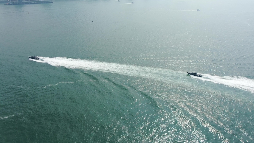 Hong Kong coastguard boats roaring across the open bay waters, Aerial view.