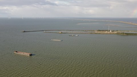Aerial shot of water around the Afsluitdijk causeway in Kornwerderzand in Friesland, the Netherlands, on a sunny day