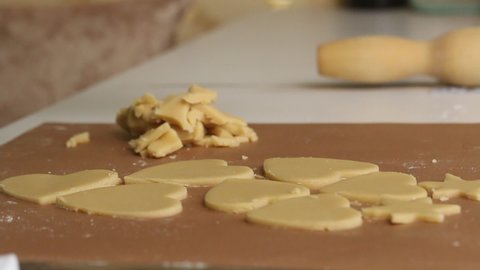 The woman works with the rolled dough. Cuts the dough into heart-shaped pieces. Prepares marshmallow sandwiches. Close-up shot