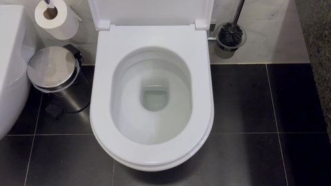 White toilet bowl top view. Flushing the toilet