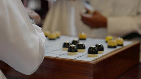 Close up of Qatari locals playing Al Dama at Souq Waqif in Doha Qatar. Majlis Al Dama council interior
