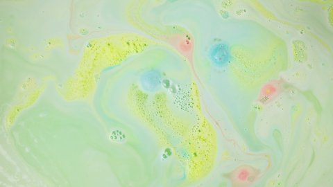 Bath bomb in water close-up. Soap ball dissolving, foam bubbles. Decorative cosmetic products for bathroom concept. Beauty and spa concept.