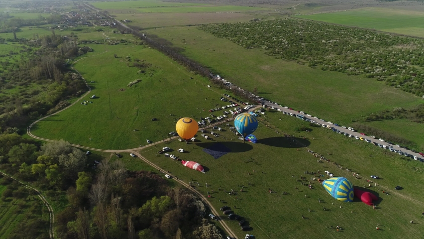 Top view of balloon festival. Shot. Beautiful summer landscape with green fields and balloon festival. Colorful balloons at ballooning Festival