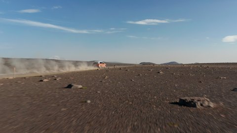 Drone view on offroad vehicle on desert road travelling in Iceland. Amazing aerial view moonscape icelandic landscape with car driving dust road exploring highlands. Commercial insurance