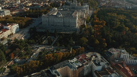 Aerial panoramic footage of large city. Amazing shot of Royal Palace and Almudena Cathedral at golden hour.