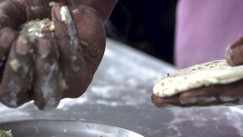 closeup shot of filling dough balls with mashed potato mixture. preparing aloo parantha. Preparing traditional North Indian breakfast.