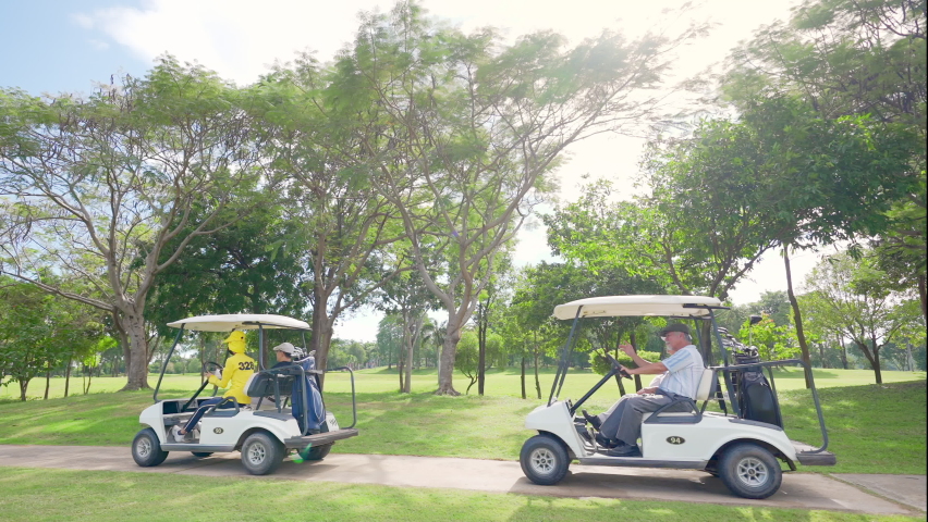 Group of Asian people businessman and senior CEO enjoy outdoor activity lifestyle sport golfing together at golf country club. Healthy men golfer driving golf cart on golf course in summer sunny day
