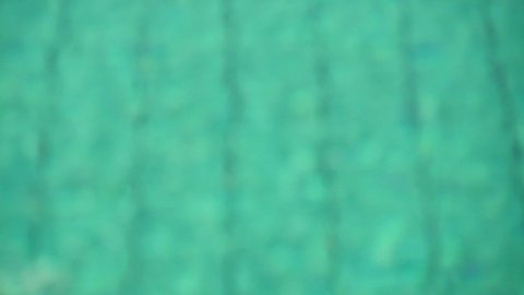 Heavily blurred defocused green turquoise pool water background. Water moves slowly, overflows sun. Green water background or screen saver for leisure, vacation, relaxation concept. Slow motion video.