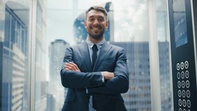 Portrait of a Successful Businessman in a Suit Riding Glass Elevator to Office in Modern Business Center. Male Turning Around to the Camera, Crossing Arms, Charmingly Smiling and Striking a Pose. - Powered by Shutterstock - Get 15% off with code: PIKWIZARD15