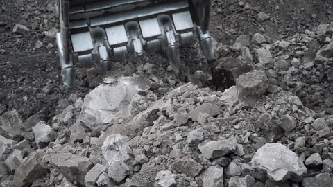 an excavator digs a rock at a coal mine
