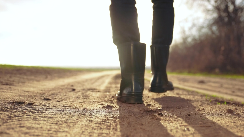 agriculture. man farmer in rubber a boots walk along road near a black field. man sunset farmer worker walk home after harvesting end of the working day feet in rubber boots agriculture Royalty-Free Stock Footage #1083977617