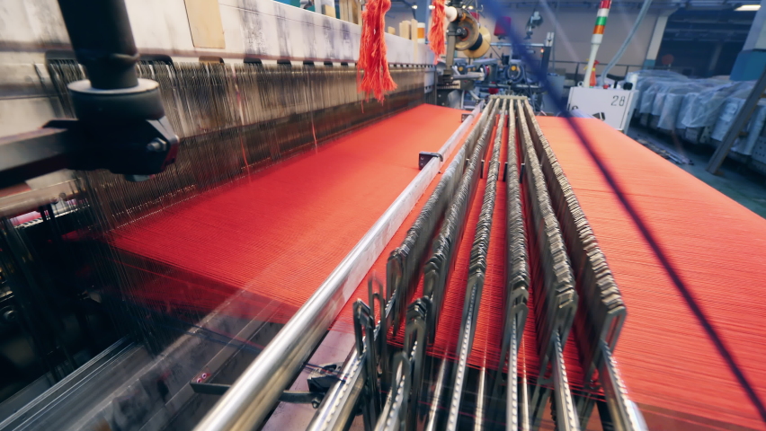 Factory mechanism is weaving fabric from red threads Royalty-Free Stock Footage #1083978367