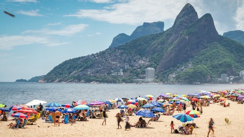 Rio de Janeiro, Brazil - December 9, 2021: Dolly right timelapse sequence showing people enjoying the summer at famous Ipanema beach in Rio de Janeiro, Brazil. 